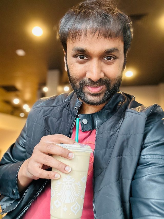 Portrait of Sankar, engineering leader and author of The Engineering Leader's Guide, smiling at the camera in a café